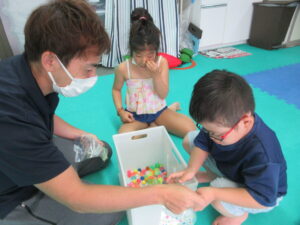 箱の中に入っているアクリルアイスを選ぶ男の子と、横で見ている女の子