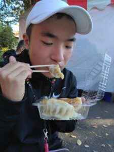 いちょう祭りで餃子を買って食べる児童