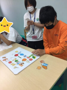 買ってくるものリストに書いてあるものをホワイトボードに並べる男の子①