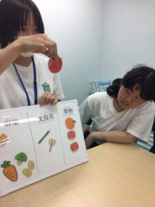 買い物のカテゴリを分けるという説明をするスタッフと、説明を聞く女の子